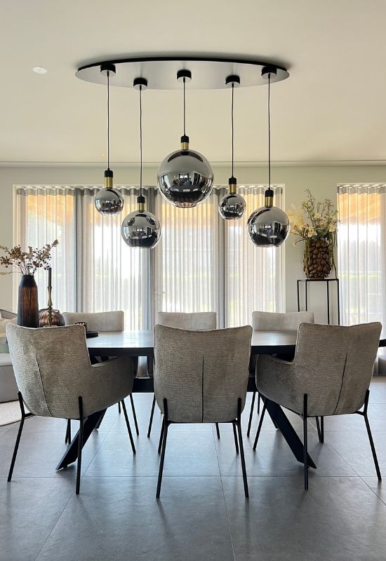 Grijze eetkamerstoelen met zwart onderstel zwart ovale eettafel hanglamp met 5 glazen bollen