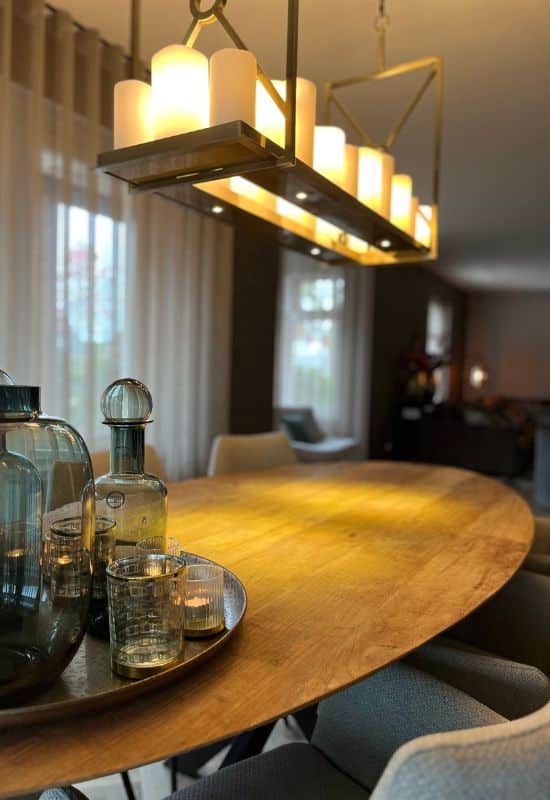 Ovale houten eettafel dienblad met glazen fles en windlichtjes