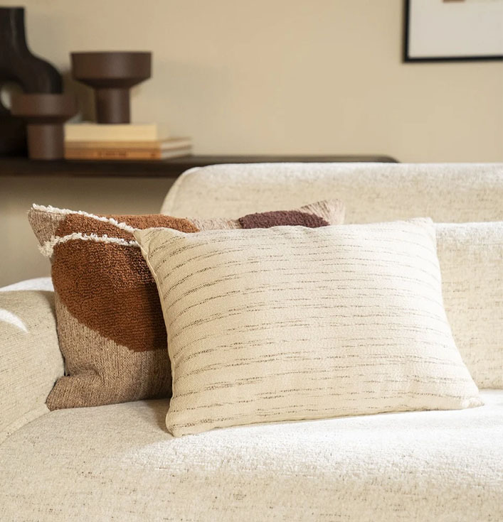 beige sierkussen op beige bank met patronen