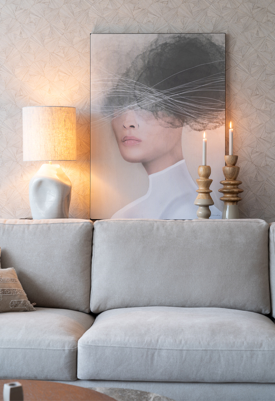 Beige hoekbank met wanddecoratie en lichte accessoires