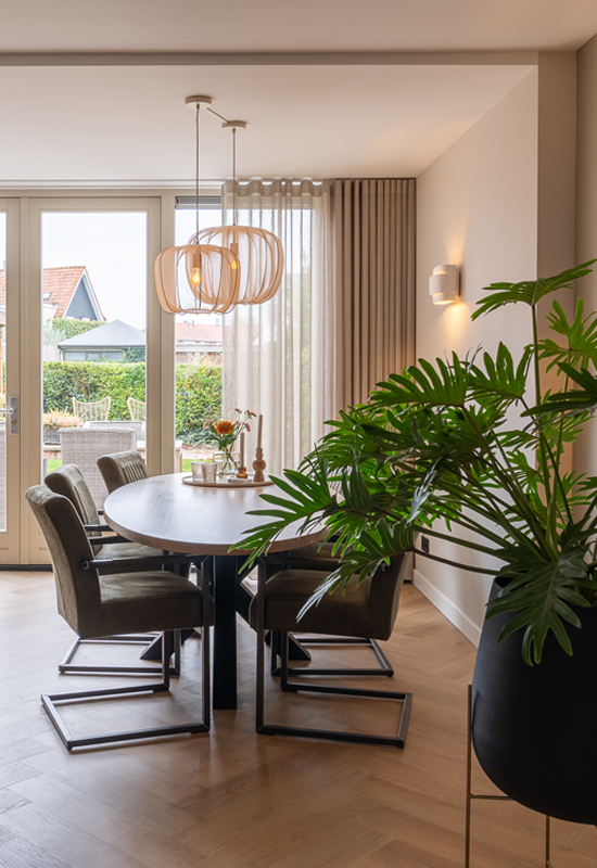 Eetkamer met ovale eettafel landelijke stoelen en luchtige hanglamp