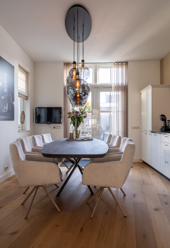 Eettafel hout met beige eetkamerstoelen en chique hanglamp