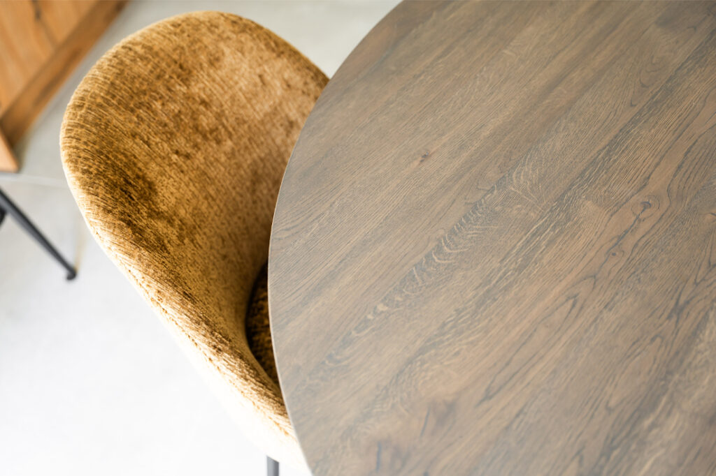 Rond hout bruin eettafel met geel opvallende eetkamerstoel